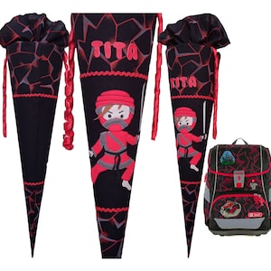 May include: A black and red school backpack with a red ninja character and the name "Tita" on the front. The backpack is decorated with a red and black geometric pattern. Two matching black and red school cones with red ninja characters and the name "Tita" are also included.