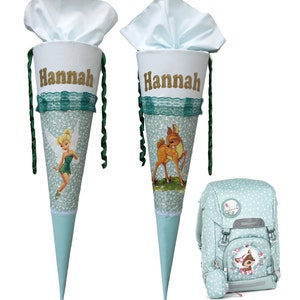Pode incluir: Dois cones escolares verdes e brancos com o nome "Hannah" neles. Um cone apresenta uma fada de desenho animado e o outro um veado de desenho animado. Também é mostrada uma mochila verde e branca de bolinhas com um design de veado.