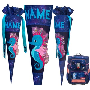 May include: A blue and pink school cone with a seahorse design and the word "NAME" on the top. The cone is decorated with glitter and stars. A blue backpack with a seahorse design and the words "Happy Day" on the front.