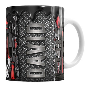 May include: A black and silver mug with a dripping black design. The mug features a diamond plate pattern and the name "DAVID" in silver letters. The mug is surrounded by a variety of tools, including wrenches, screwdrivers, and pliers.