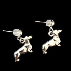Op de afbeelding: Een paar zilveren dackel oorbel studs. De oorbellen zijn klein en hebben een gedetailleerd dackel ontwerp.