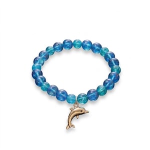 May include: A stretch bracelet composed of round, translucent blue and teal beads. The bracelet features a single metallic gold-toned dolphin charm suspended from a small silver-toned jump ring, centered at the bottom of the circular bead arrangement.