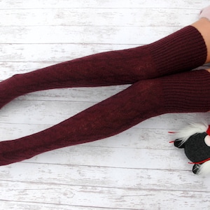 K&ouml;nnte beinhalten: Ein Paar burgunderfarbene Oberschenkelsocken mit gerippter Struktur. Die Socken sind aus einem weichen, warmen Material gefertigt und perfekt, um Ihre Beine im Winter warm zu halten.