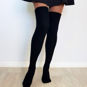 K&ouml;nnte beinhalten: Ein Paar schwarze Oberschenkelsocken mit Rippenstruktur.