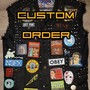 Może przedstawiać: Czarna dżinsowa kamizelka z różnymi naszywkami, w tym logo zespołów, tytułami filmów i innymi wzorami. Kamizelka jest ozdobiona srebrnymi kolcami i ma strzępiony brzeg. Na przodzie kamizelki widnieje napis "CUSTOM ORDER".