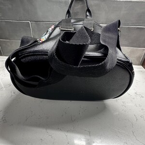 May include: A white ceramic mug with a black handle and the text "But First, Coffee" in a handwritten style. The mug is on a white surface. The mug is 4 inches tall.