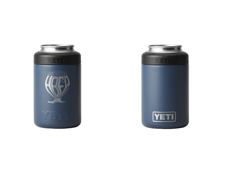 May include: Two navy blue YETI can coolers. One cooler features the text "ABEF" in a stylized design, and the other has the YETI logo. Both have a black top and silver rim.