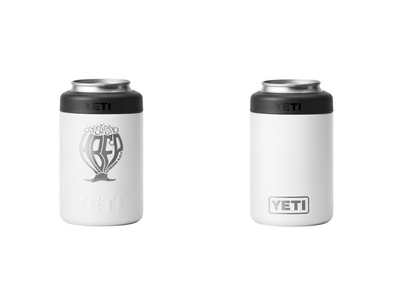 May include: Two white YETI can insulators. One features a silver graphic of a beer design with the word "BEER" and the text "Brewed Right". The other has the YETI logo. Both have a black top and silver rim.