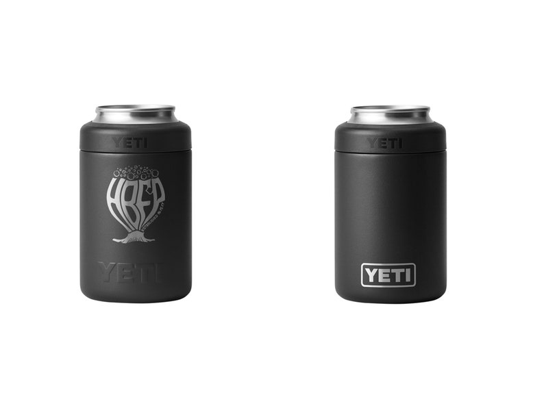 May include: Two black YETI can insulators. One features the word "HREF" in a stylized design with a tree-like base and the YETI logo. The other has a plain black surface with the YETI logo in a white rectangle.