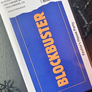May include: A blue and orange Blockbuster-themed item. The word "BLOCKBUSTER" is in large orange letters on a blue background. The item also includes the text "Keshia's House Party".