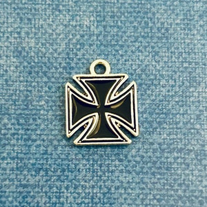 May include: A black iron cross charm with a gold finish. The charm is a popular symbol of strength and protection.