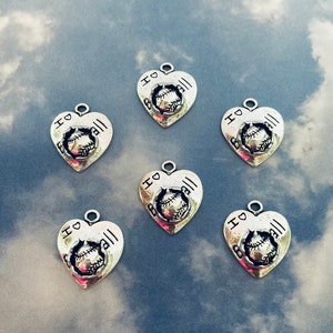 May include: Six silver heart-shaped charms with the words "I love ball" and a baseball graphic.