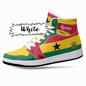 Puede incluir: Zapatillas blancas de ca&ntilde;a alta con un dise&ntilde;o rojo, amarillo, verde y negro que representa la bandera de Ghana. La palabra "Ghana" est&aacute; escrita en el lateral de la zapatilla.