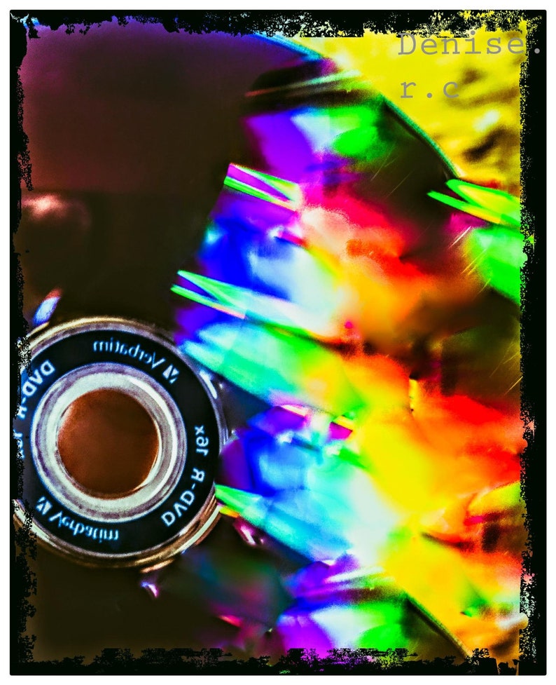 May include: A close-up of a DVD-R disc with a rainbow-like reflection. The disc is labeled "DVD-R 1x" and "midr.v.m."