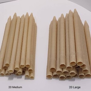 Puede incluir: Dos pilas de palitos masticables de color beige para perros. La pila de la izquierda está etiquetada como "20 Medium" y la pila de la derecha está etiquetada como "20 Large".