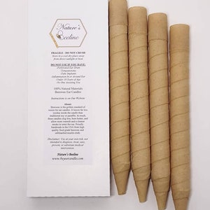 Puede incluir: Un paquete de cinco velas para oídos de cera de abeja beige con una etiqueta blanca que dice "Nature's Beeline" e incluye instrucciones de uso y una exención de responsabilidad. La etiqueta también indica que las velas están hechas con materiales 100% naturales.