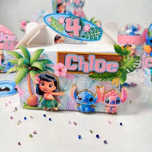 May include: White party favor box decorated with Lilo & Stitch characters, palm trees, and tropical flowers. The box features the name "Chloe" and the number "4" in pink and blue. The overall theme is a Hawaiian luau birthday party.