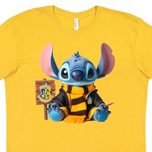 May include: Yellow t-shirt with a blue Stitch character wearing a black and yellow Hogwarts house scarf and holding a wand. The shirt has a Hogwarts house crest on the side.