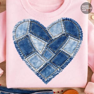 May include: A light pink sweatshirt featuring a large heart design made of denim patches. The heart is composed of various shades of blue denim, stitched together with visible gold thread. The design has a frayed edge. The text "PRETTY VECTORS LAB" is visible.