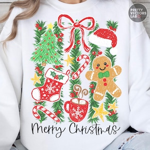 Könnte beinhalten: Ein weißes Sweatshirt mit einem festlichen Grafikdruck, der einen Weihnachtsbaum, eine rote Schleife, eine Weihnachtsmütze, eine Zuckerstange, einen Strumpf, einen Lebkuchenmann und eine Tasse heißen Kakao zeigt. Der Text Merry Christmas steht unten.