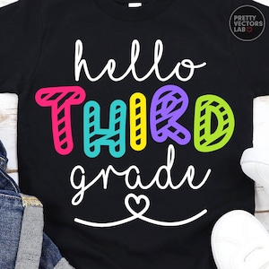 May include: A black short-sleeved t-shirt featuring the white cursive text hello, the colorful block letters THIRD in pink, teal, yellow, purple, and lime green, and the white cursive text grade with a heart icon underneath the lettering.