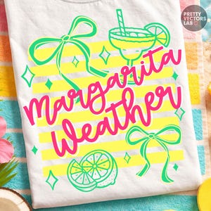 May include: White t-shirt with the words "Margarita Weather" in pink script, accented with green bows, a margarita glass, and a lime slice. Yellow horizontal stripes and diamond shapes add to the design.
