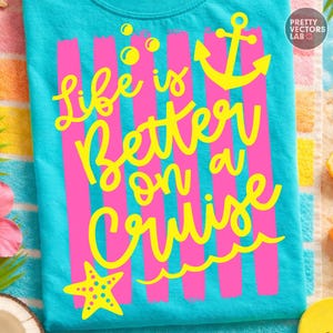 May include: A turquoise t-shirt with the phrase "Life is Better on a Cruise" in yellow script. The design includes pink vertical stripes, a yellow anchor, starfish, and bubbles. The shirt is made of a soft material.