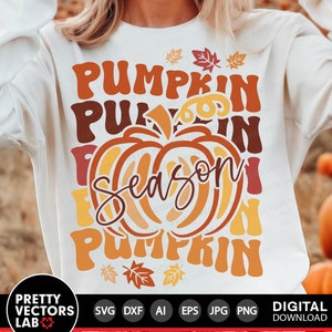 May include: A white sweatshirt with a graphic design featuring a pumpkin with the text "Pumpkin Season Pumpkin" in a retro style. The text is in orange, yellow, and brown.