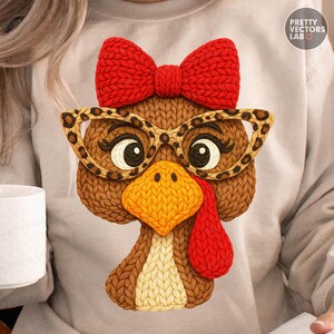 May include: A light gray sweatshirt featuring a knitted turkey design. The turkey has a red bow, leopard print glasses, and a yellow beak. The turkey's wattle is red. The design is from Pretty Vectors Lab.