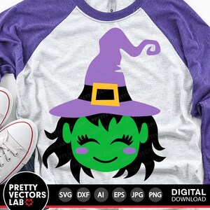 May include: A digital download of a green witch with purple hat and black hair. The witch has a happy expression with closed eyes and rosy cheeks. The image is on a white and purple t-shirt.