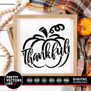 May include: Black and white silhouette of a pumpkin with the word "Thankful" written inside. The pumpkin is on a white background with a wooden frame.