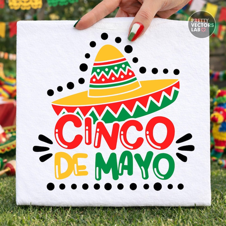K&ouml;nnte beinhalten: Quadratischer wei&szlig;er Stoff mit einem farbenfrohen Cinco de Mayo-Design. Das Design zeigt einen gelben Sombrero mit roten und gr&uuml;nen Akzenten und die Worte "CINCO DE MAYO" in Rot und Gr&uuml;n. Schwarze Punkte und Linien umgeben den Text und den Hut.