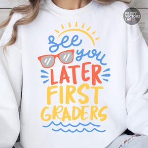Puede incluir: Sudadera blanca con el texto "See you later First Graders" en azul, naranja y amarillo. El dise&ntilde;o incluye un sol amarillo, gafas de sol rojas y olas azules. La sudadera es de estilo casual.