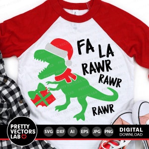 Puede incluir: Una camiseta de estilo b&eacute;isbol blanca y roja con un dinosaurio verde que lleva un gorro de Pap&aacute; Noel y sostiene una caja de regalo roja. El texto "Fa La Rawr Rawr Rawr" est&aacute; impreso en la camiseta.