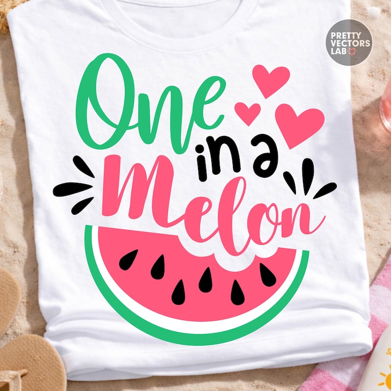 May include: A white t-shirt featuring a graphic design with the text One in a Melon in green, black, and pink script and block lettering. The design includes three pink hearts and a large watermelon slice graphic with black seeds at the bottom.