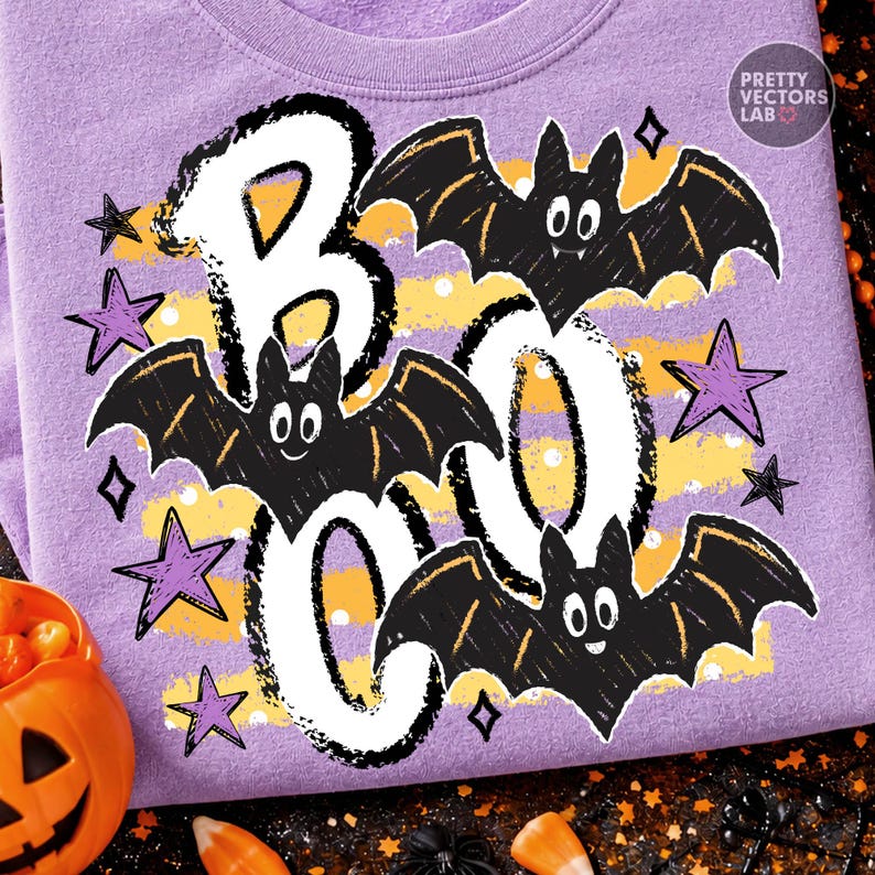 May include: A light purple sweatshirt featuring a graphic print with the white text BOO, three black bats, and purple stars. The design includes yellow horizontal stripes with white polka dots and a small logo reading PRETTY VECTORS LAB.