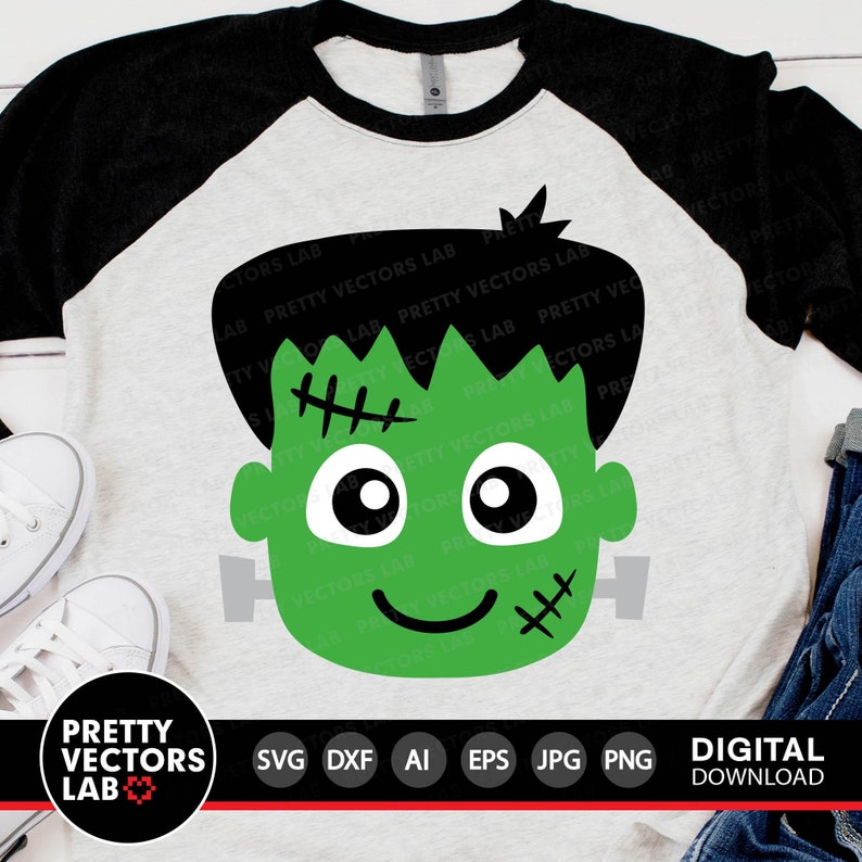 May include: A raglan-style t-shirt with a light gray body and black sleeves. The shirt features a green Frankenstein's monster face graphic. The graphic includes black hair, stitches, and a smiling face. The bottom of the image includes the text "PRETTY VECTORS LAB".