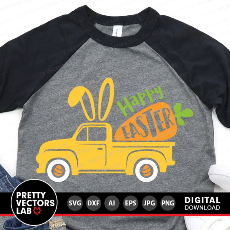 Puede incluir: Una camioneta amarilla con orejas de conejo en la cabina, transportando una zanahoria con el texto "Happy Easter" en ella. La camioneta est&aacute; en una camiseta gris y negra de manga raglan.