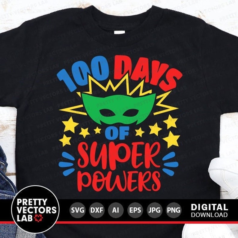 Pode incluir: Uma camiseta preta com o texto "100 Days of Super Powers" em letras coloridas. Uma m&aacute;scara de super-her&oacute;i verde com um design de raio amarelo est&aacute; acima do texto. H&aacute; cinco estrelas amarelas de cada lado do texto.