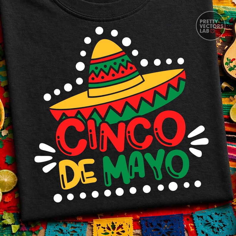 K&ouml;nnte beinhalten: Schwarzes T-Shirt mit einem Cinco de Mayo-Design. Das Design zeigt einen gelben Sombrero mit roten und gr&uuml;nen Akzenten und die Worte "Cinco de Mayo" in Rot, Gr&uuml;n und Gelb.