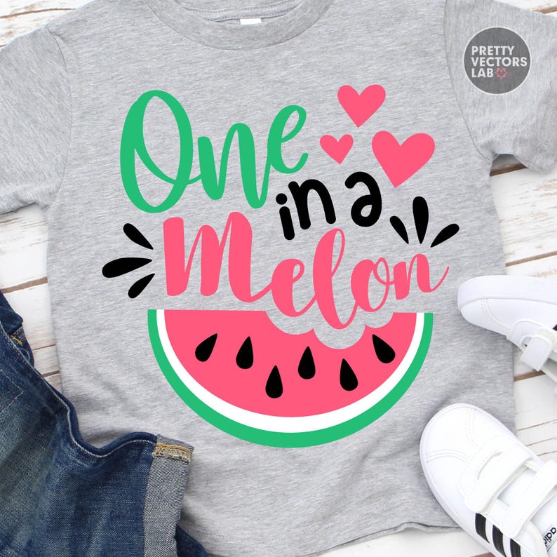 May include: A heather gray t-shirt featuring the text One in a Melon in green, black, and pink script and print fonts. The design includes three pink hearts and a graphic of a watermelon slice with black seeds at the bottom of the shirt.