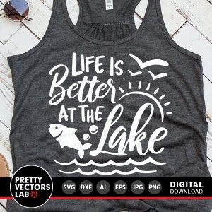 Puede incluir: Una camiseta sin mangas gris con el texto "Life is Better at the Lake" en blanco. El texto est&aacute; rodeado de un pez, un sol y olas.