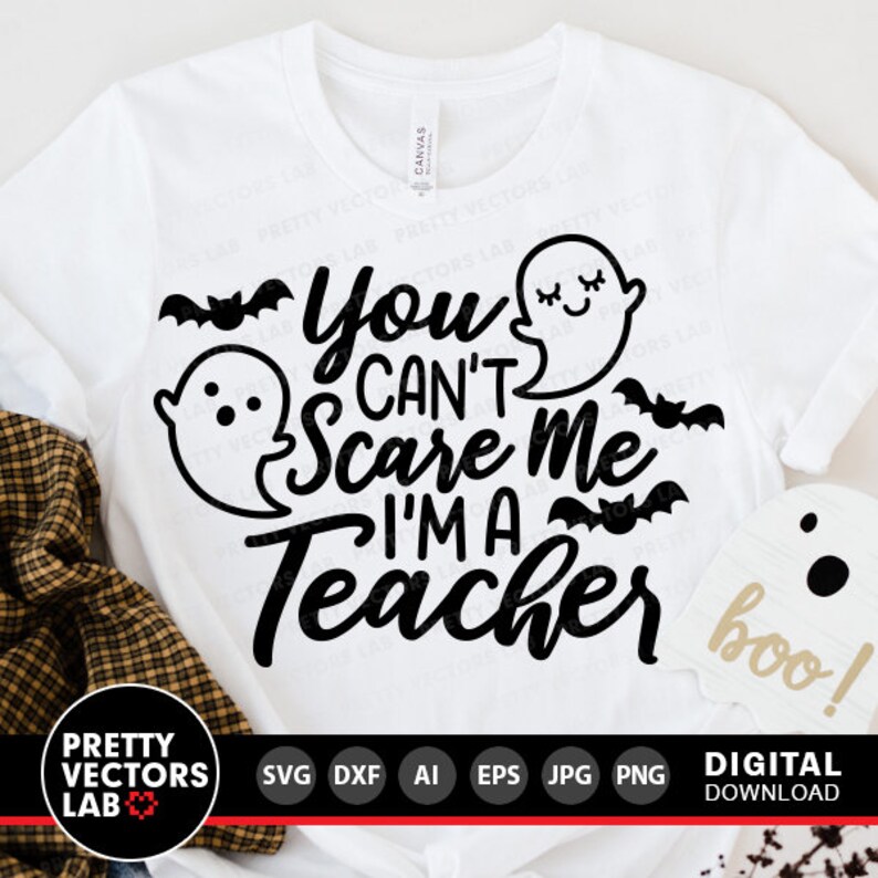 May include: White t-shirt with a black graphic that says "You Can't Scare Me I'm A Teacher" with ghosts and bats. The text "boo!" is in the bottom right corner.