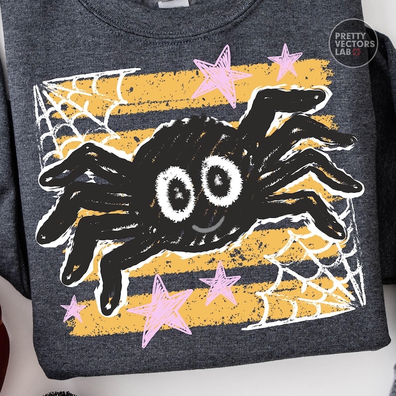 May include: A dark gray sweatshirt featuring a graphic print of a black spider with large white eyes and a small smile. The design includes yellow horizontal stripes, white spiderwebs in the corners, and pink stars. Text reads Pretty Vectors Lab.