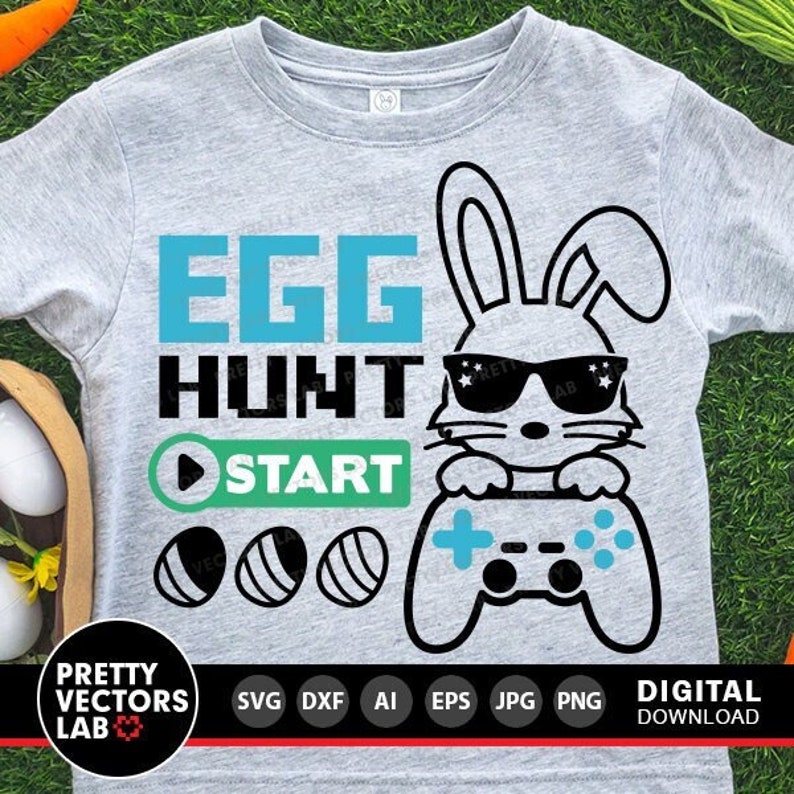K&ouml;nnte beinhalten: Ein graues T-Shirt mit einer blauen und wei&szlig;en Grafik eines Kaninchens mit Sonnenbrille, das einen Videospiel-Controller h&auml;lt. Der Text "EGG HUNT START" ist in Blau und Gr&uuml;n auf dem T-Shirt gedruckt.