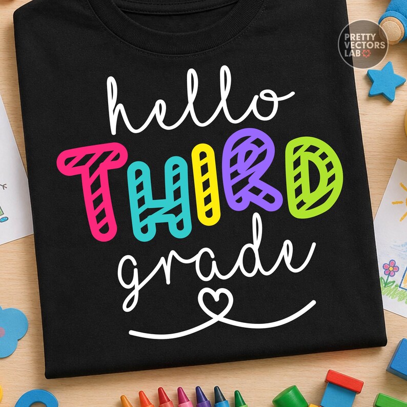 May include: A black t-shirt featuring the white cursive text hello, the word THIRD in large, colorful, striped block letters in pink, teal, yellow, purple, and lime green, and the white cursive text grade with a small heart icon underneath.