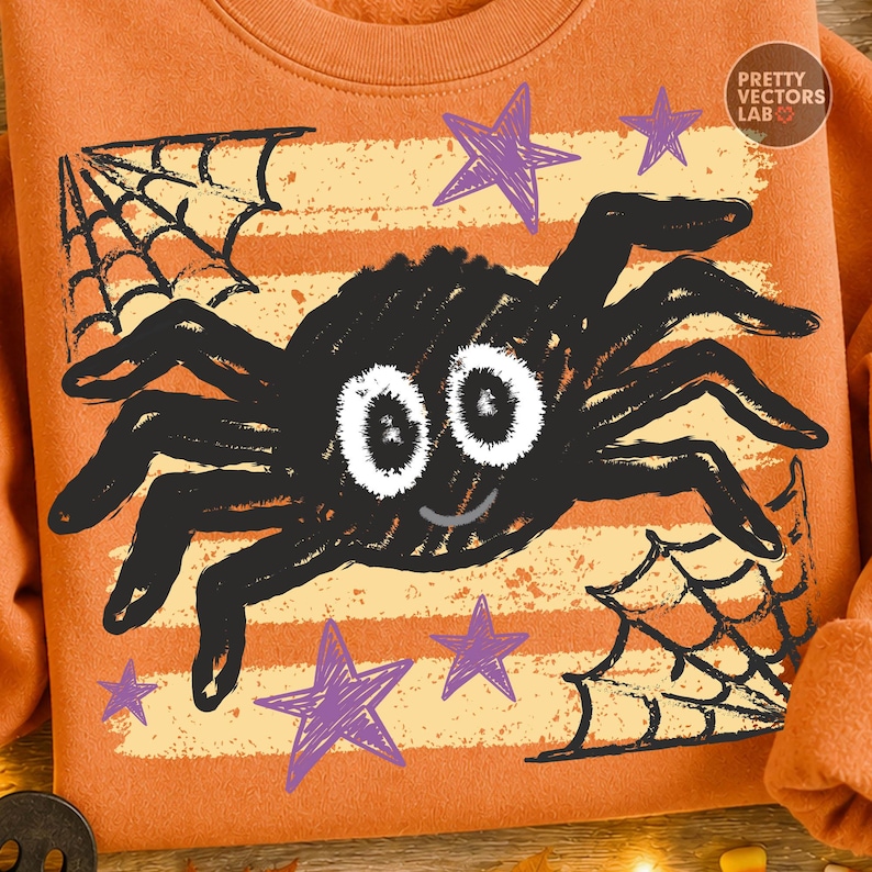 May include: An orange sweatshirt featuring a graphic print of a black spider with large white eyes and a small smile. The design includes purple stars and black spiderwebs over horizontal light orange stripes. The text Pretty Vectors Lab is visible.