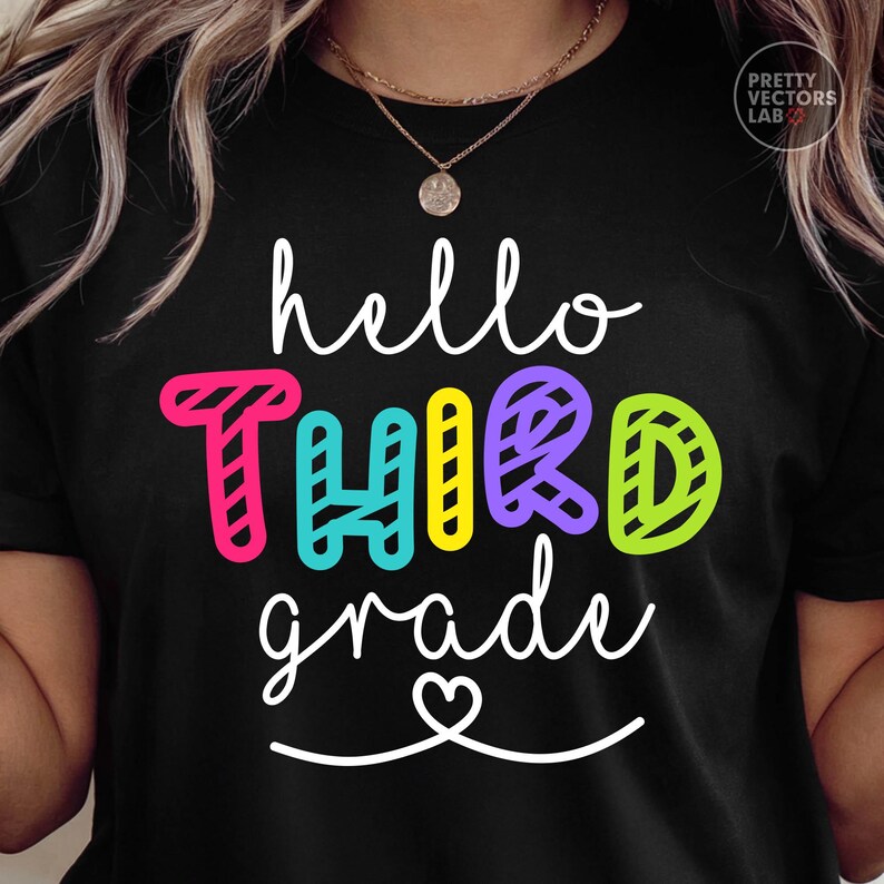 May include: A black t-shirt featuring the white cursive text hello and grade with a small heart icon. The word THIRD is printed in large, colorful, block letters with a diagonal striped pattern in shades of pink, teal, yellow, purple, and lime green.