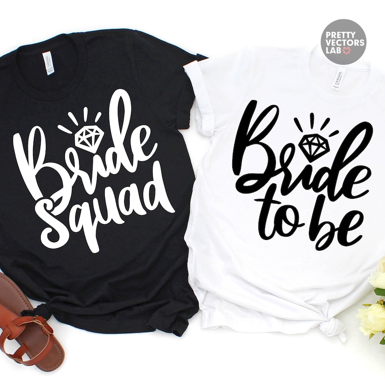 May include: A black t-shirt with white text reading Bride Squad and a white t-shirt with black text reading Bride to be. Both shirts feature a diamond graphic above the text. The shirts are short-sleeved with a crew neckline and casual fit.