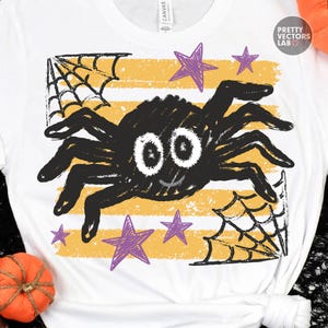 May include: A white t-shirt featuring a graphic of a black spider with large white eyes, a small smile, and eight legs. The design includes yellow horizontal stripes, black spiderwebs in the corners, and purple stars. The text Pretty Vectors Lab is visible.